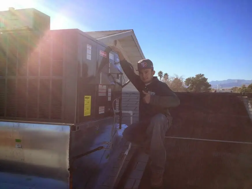 HVAC technician performing Air Duct Repair on a rooftop unit in Milton-Freewater